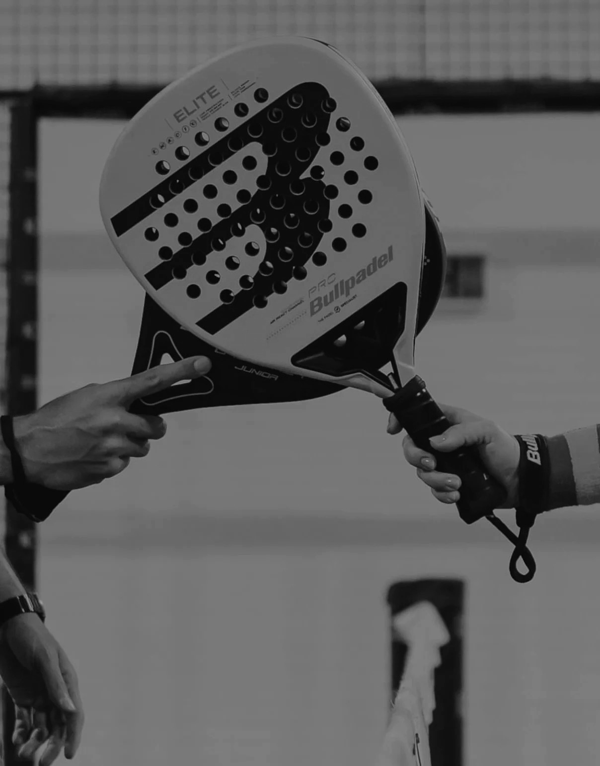 Two players meeting at the net, padel rackets in hand